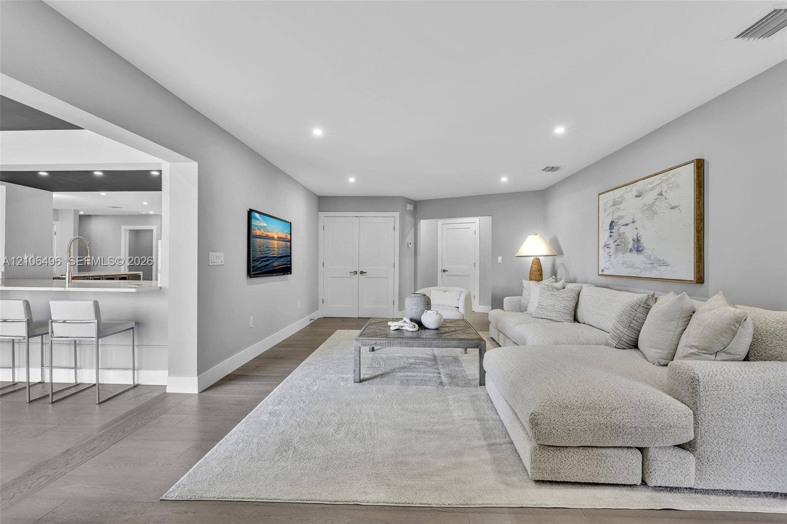 Open floor plan featuring wood-finish flooring, recessed lighting, and a breakfast bar with stone countertop