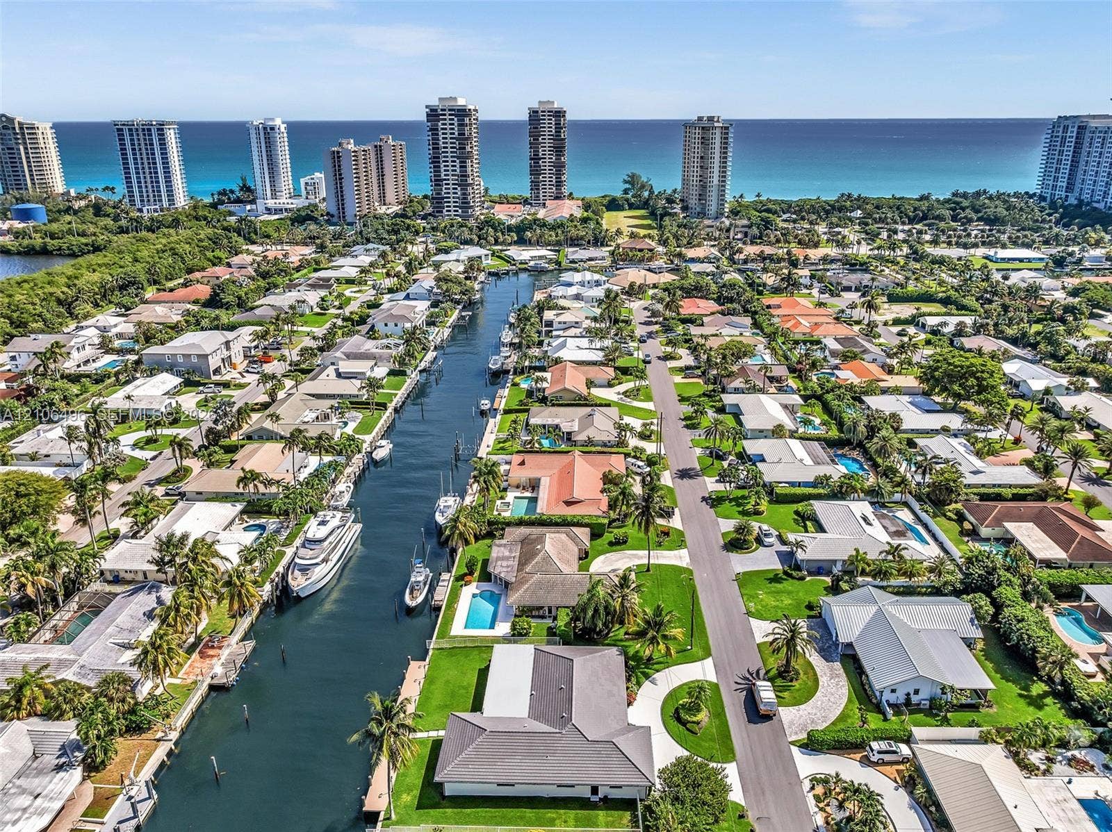 Aerial perspective of a coastal residential community featuring deep-water canal access, private boat docks, and established landscaping