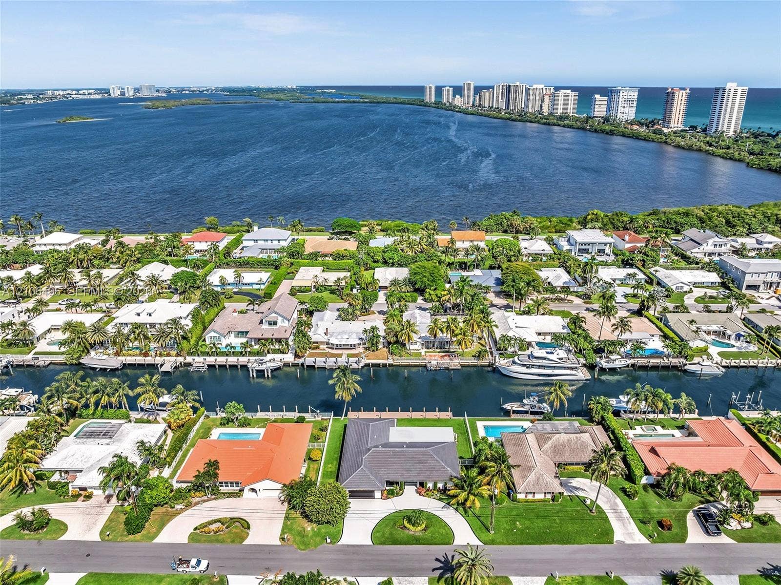 Aerial perspective of waterfront properties featuring deep-water canal access, private boat docks, and manicured landscaping