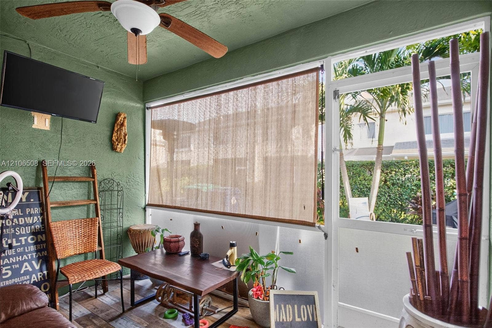 Enclosed porch featuring textured walls, a ceiling fan with integrated lighting, wood-finish flooring, and a glass-paneled screen door