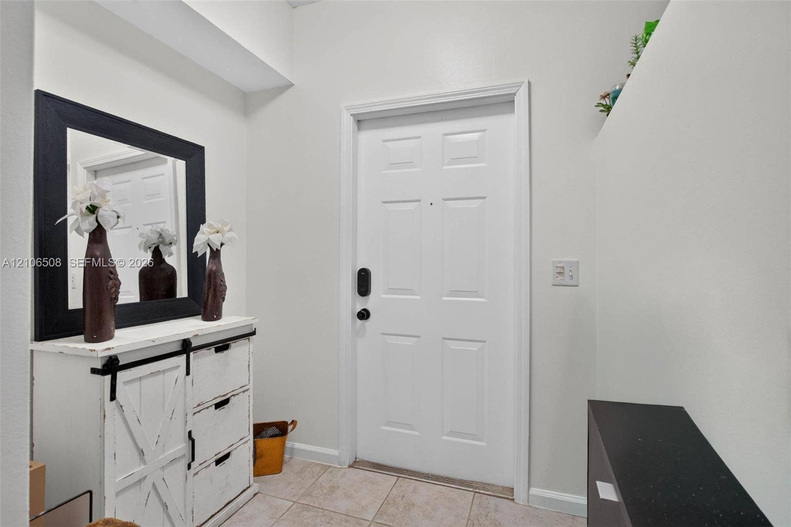 Entryway featuring a white paneled door with electronic deadbolt hardware and ceramic tile flooring