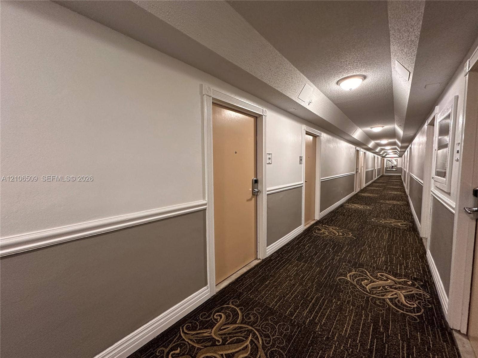 Hallway featuring patterned carpeting, two-toned wall paint, decorative chair rail molding, and recessed ceiling lighting