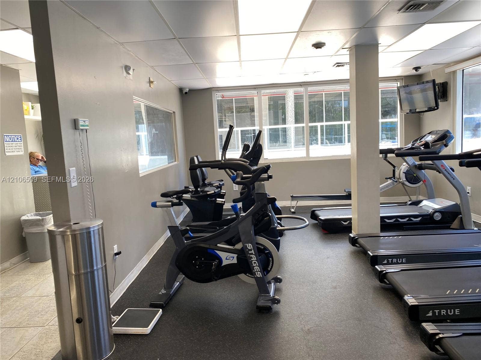 Fitness center featuring rubberized flooring, expansive windows with natural light, and recessed ceiling lighting