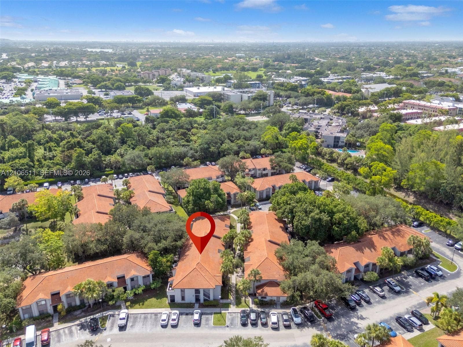 3229 Coral Lake Drive, #3229, Coral Springs, FL 33065 Aerial perspective of multi-family residential complex featuring terracotta-tiled roofs, stucco exterior finish, mature shade trees, and surface parking