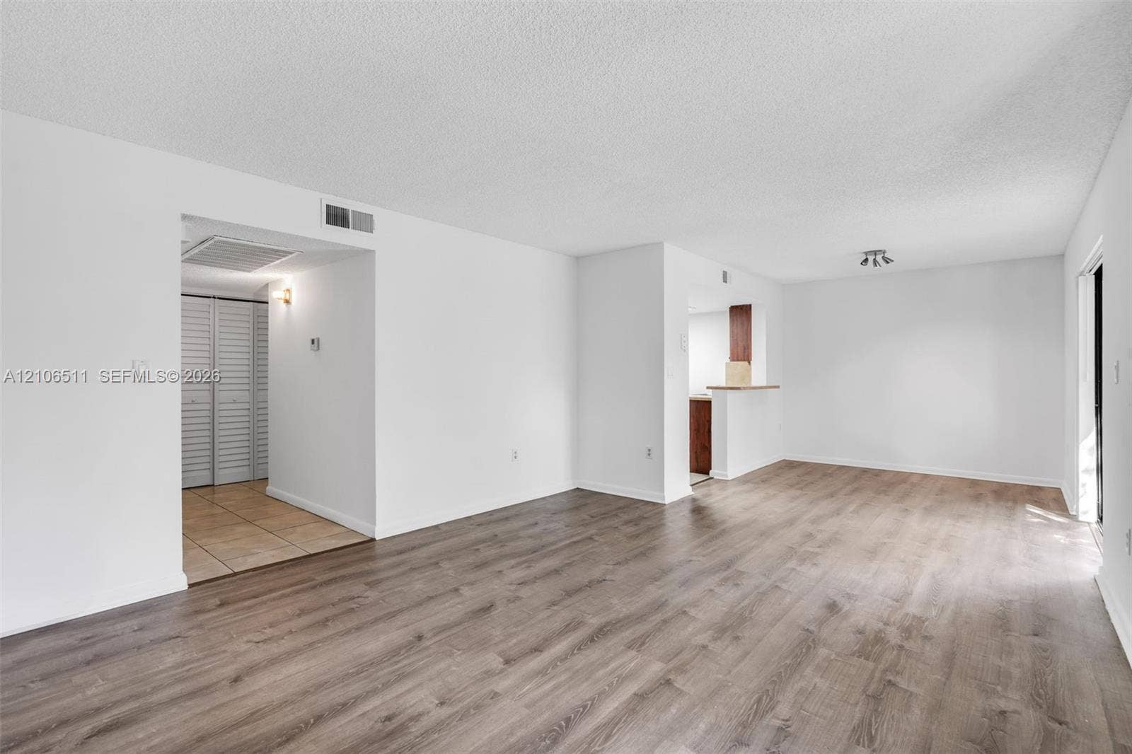 3229 Coral Lake Drive, #3229, Coral Springs, FL 33065 Open-concept interior featuring wood-finish flooring, neutral walls, recessed light fixture, and built-in closet with louvered doors