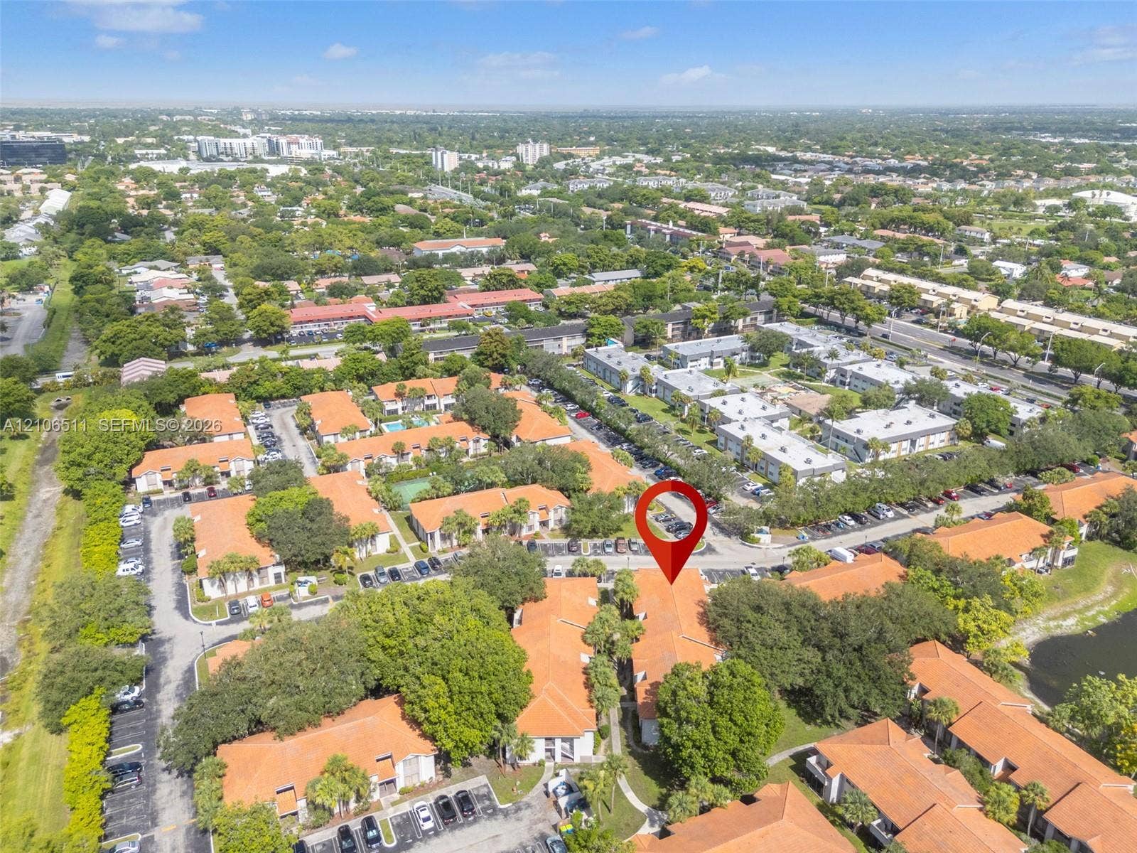 3229 Coral Lake Drive, #3229, Coral Springs, FL 33065 Aerial view featuring a multi-unit residential complex with terracotta-style roof tiles, mature landscaping, and dedicated surface parking