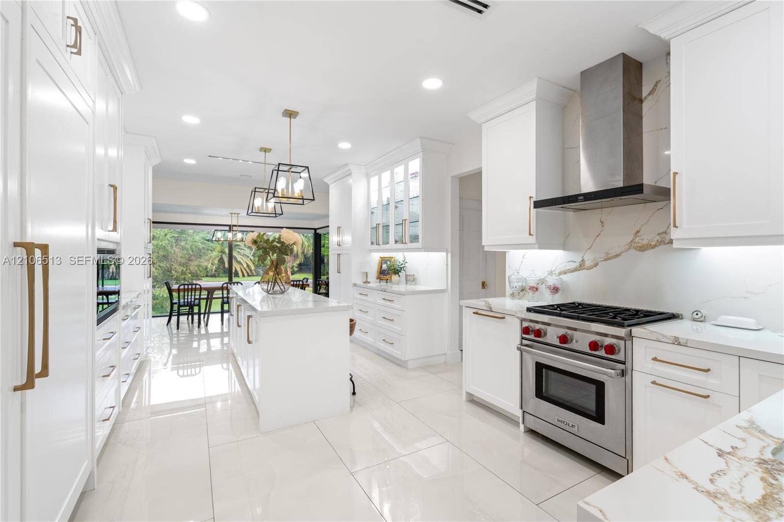 5720 SW 128th Street, Pinecrest, FL 33156 Kitchen featuring white Shaker-style cabinetry, a central island with a stone-finish countertop, stainless steel professional-grade range, full-height stone-finish backsplash, and polished tile flooring