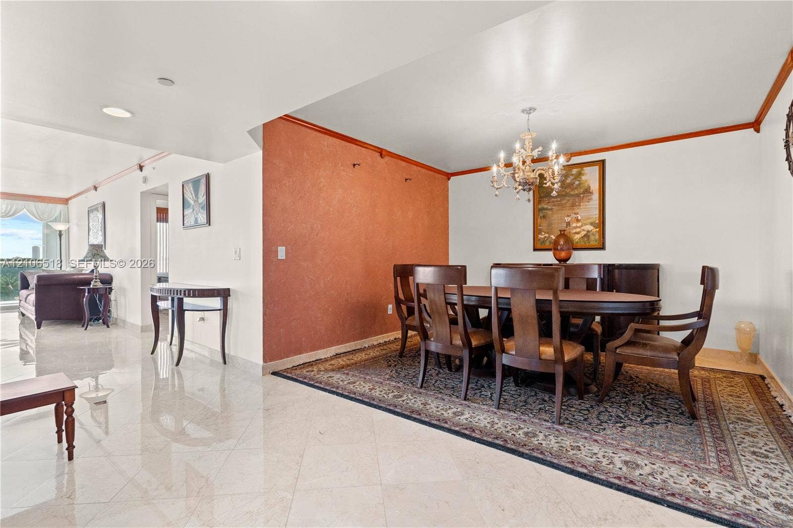 16500 Collins Avenue, #554, Sunny Isles Beach, FL 33160 Polished stone flooring, textured accent wall, crown molding, and a tiered crystal chandelier