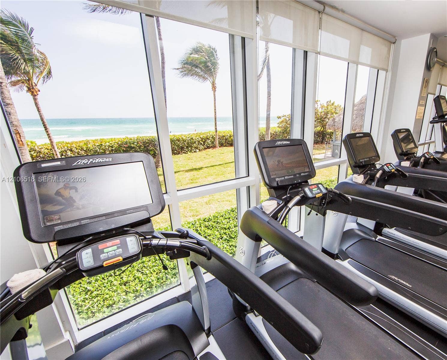 16500 Collins Avenue, #554, Sunny Isles Beach, FL 33160 Floor-to-ceiling windows, ocean horizon backdrop, and fitness center with professional-grade equipment