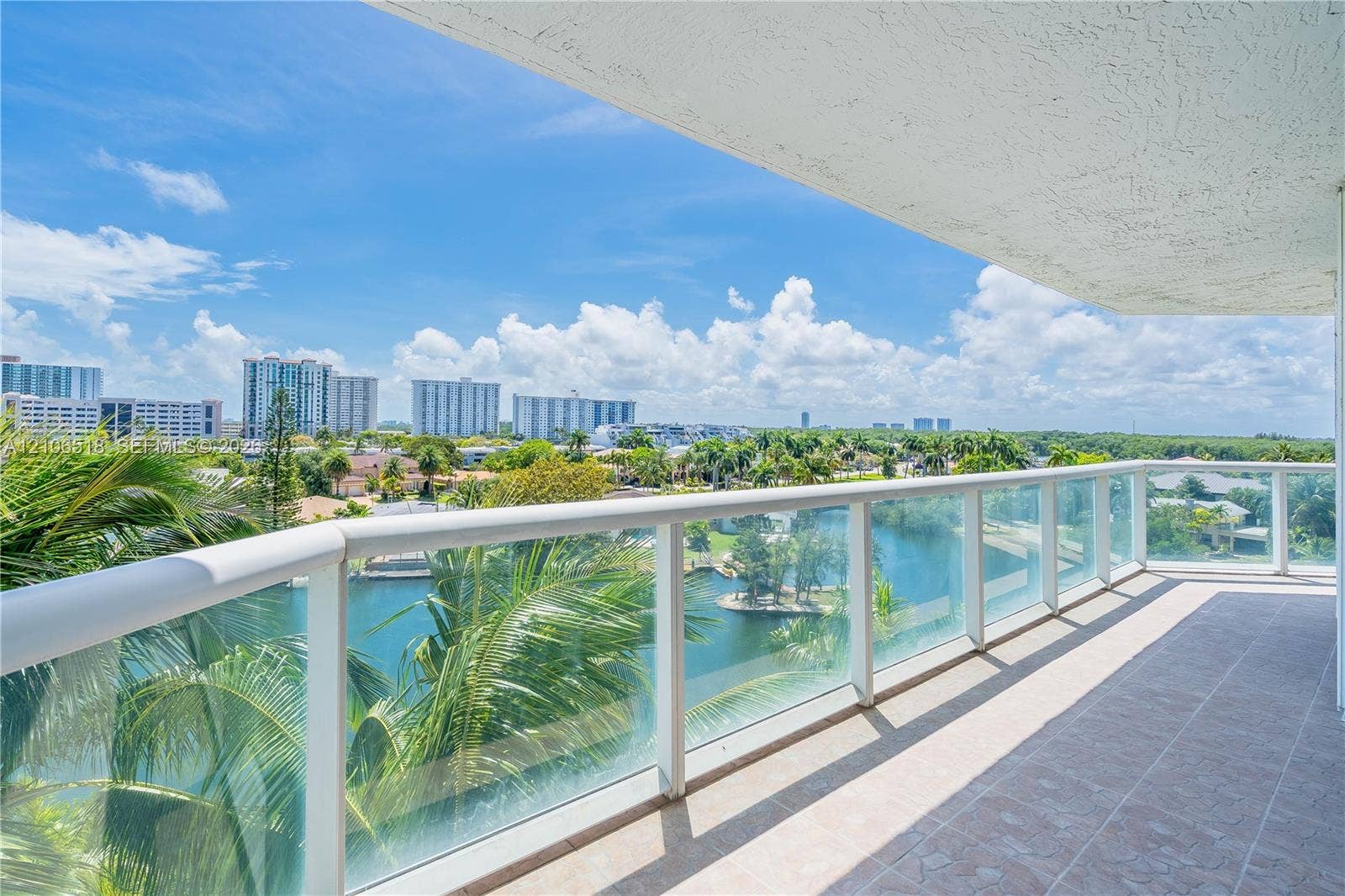 16500 Collins Avenue, #554, Sunny Isles Beach, FL 33160 Covered balcony featuring tile flooring and a glass-paneled railing overlooking the water