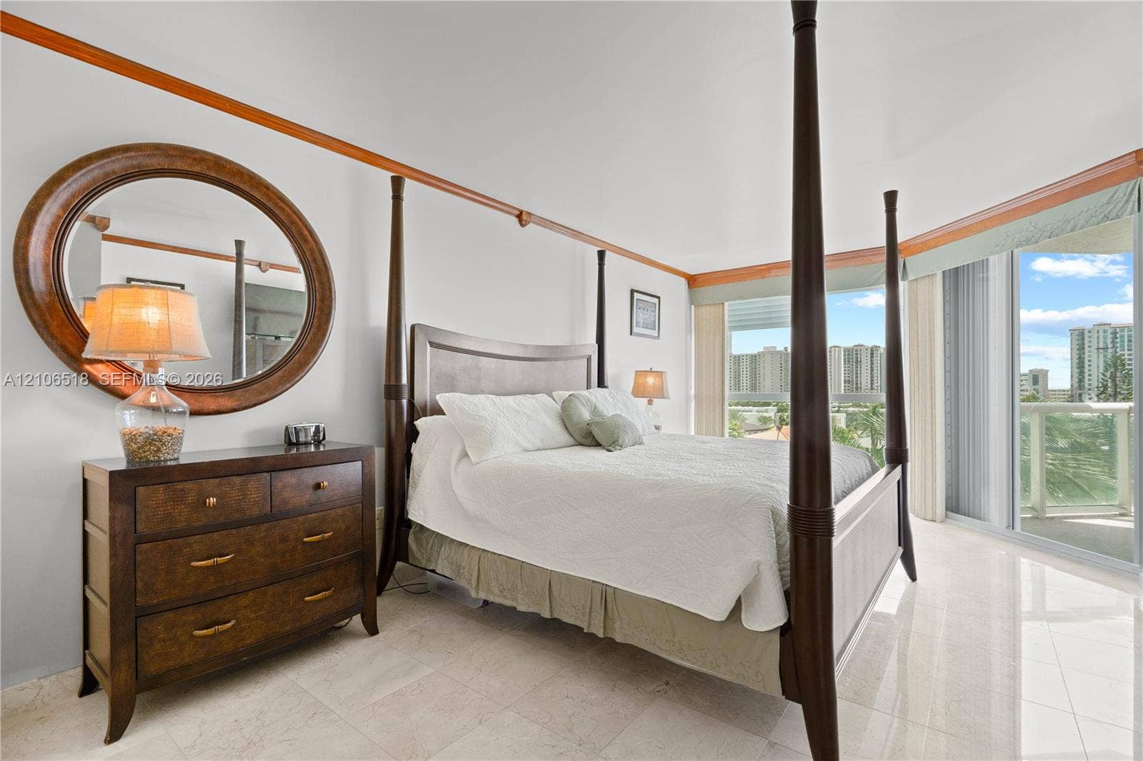 16500 Collins Avenue, #554, Sunny Isles Beach, FL 33160 Spacious room featuring light-toned stone flooring, custom natural wood crown molding, and floor-to-ceiling glass sliding doors opening to an outdoor terrace