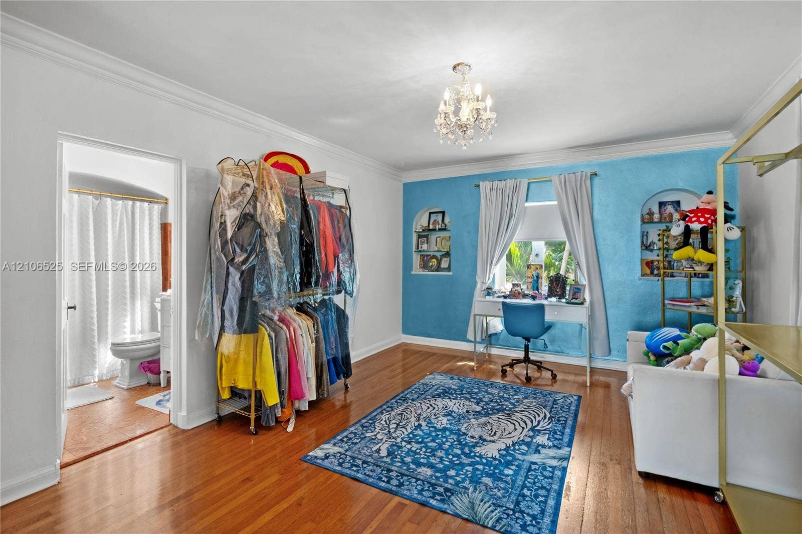 4760 N Bay Road, Miami Beach, FL 33140 Hardwood flooring, crown molding, arched wall niches, and a multi-arm crystal chandelier