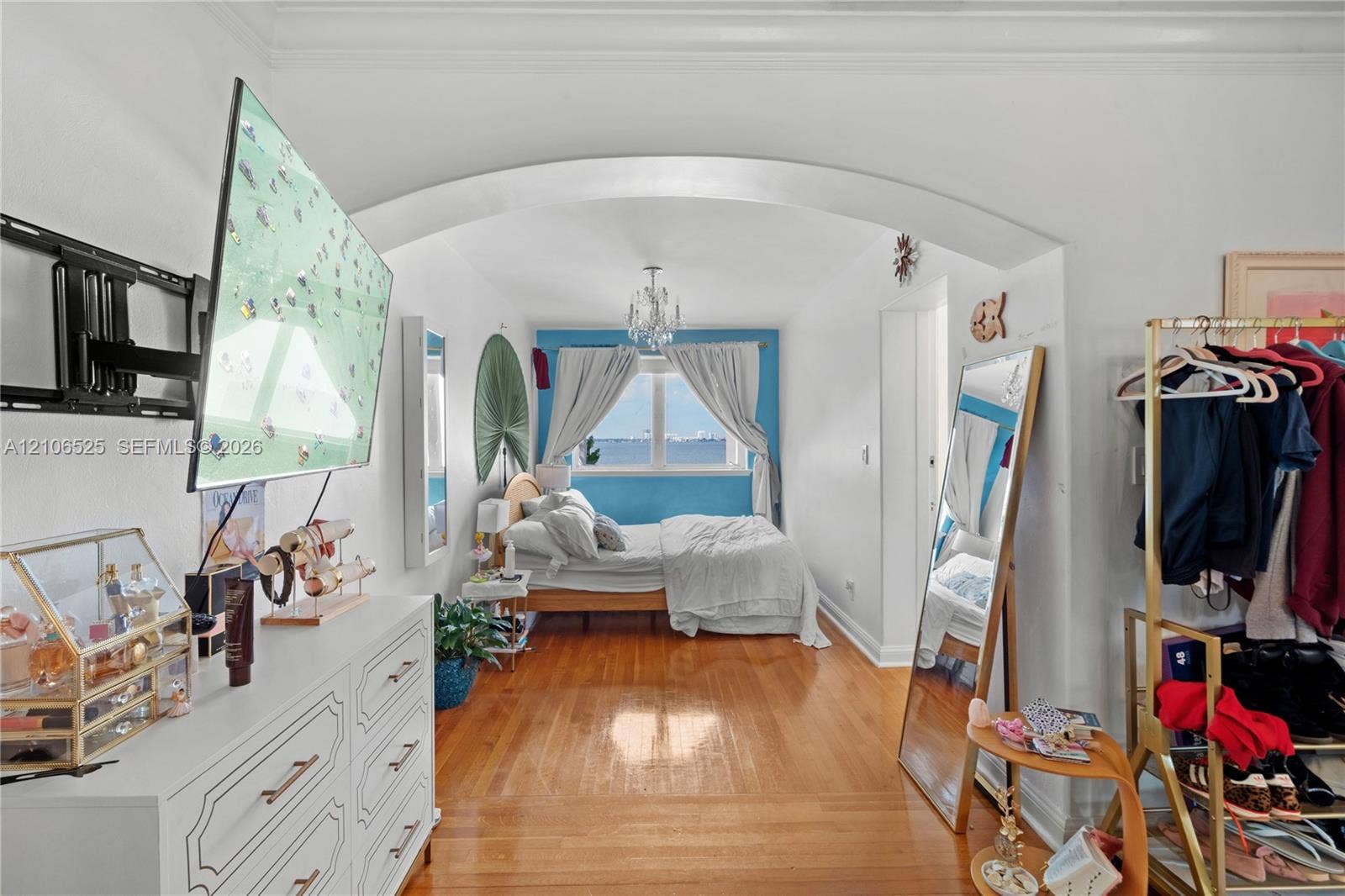 4760 N Bay Road, Miami Beach, FL 33140 Architectural arched entryway, wood-finish flooring, and ceiling-mounted crystal chandelier