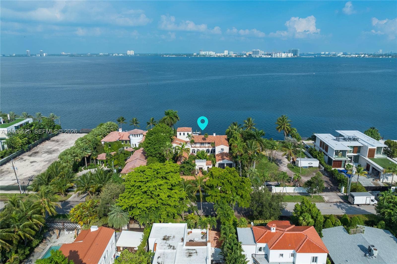 4760 N Bay Road, Miami Beach, FL 33140 Waterfront estate featuring a tile roof, multi-level terraces, mature landscaping, and an expansive parcel