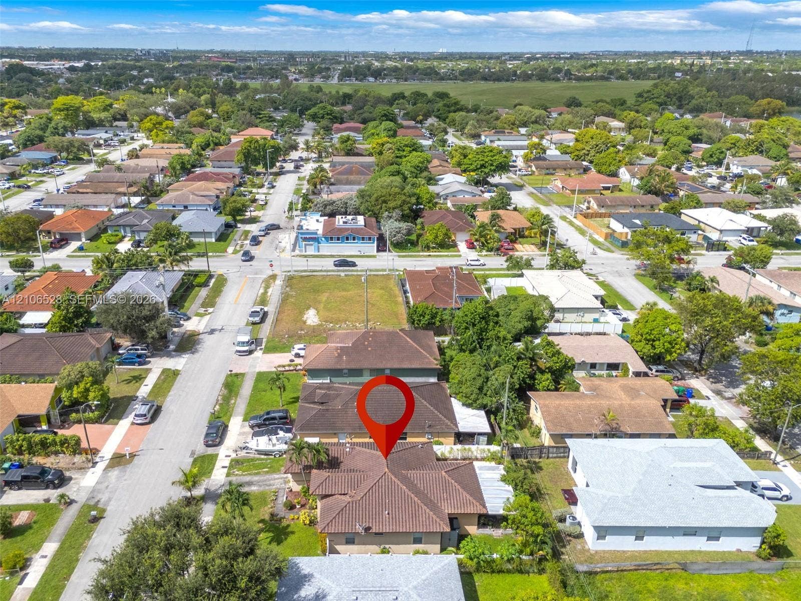 2615 NW 14th Street, Fort Lauderdale, FL 33311 Aerial perspective of a single-story residence featuring a hipped roof with clay-style tiles, situated on a landscaped lot with mature trees