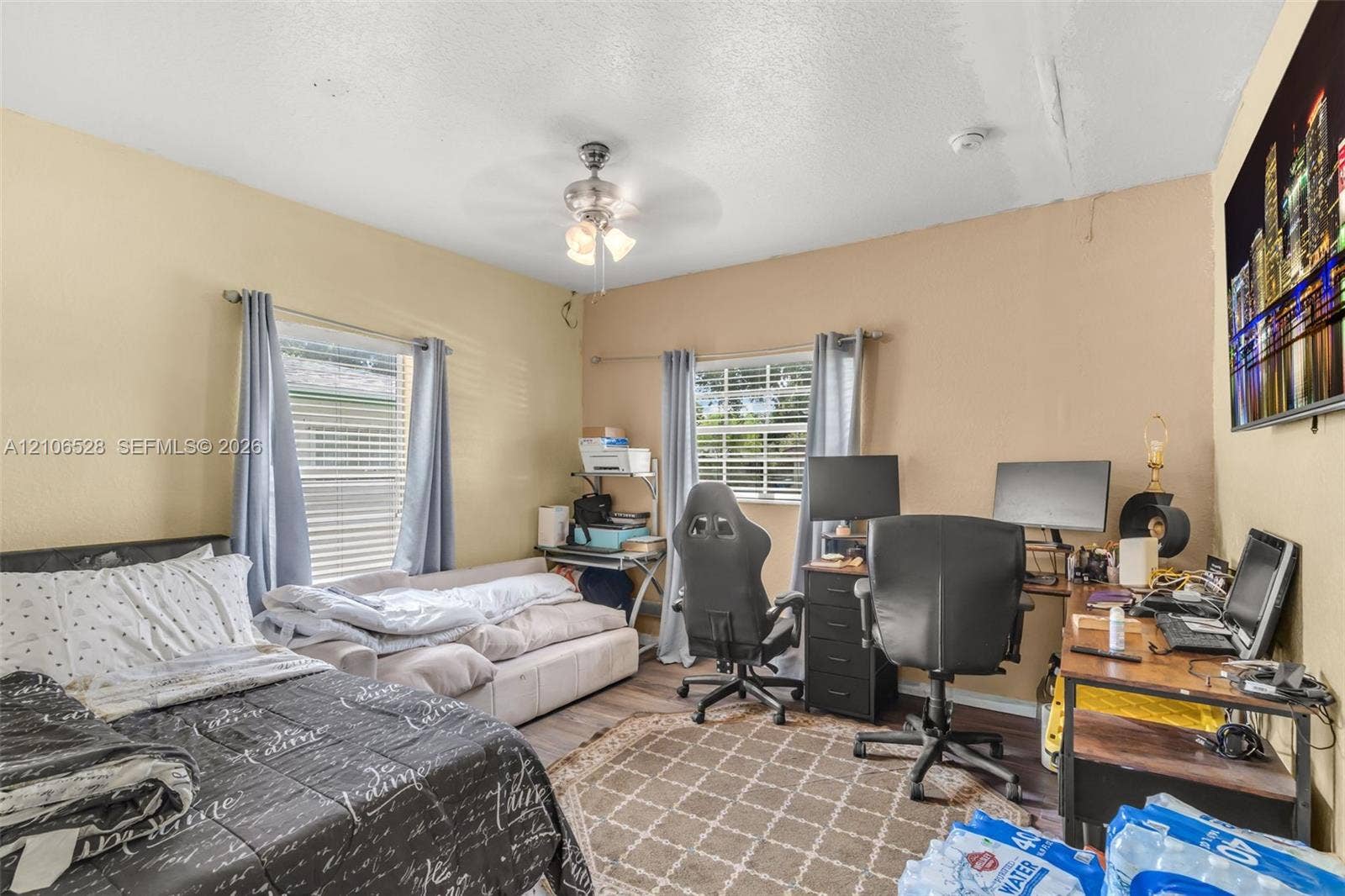 2615 NW 14th Street, Fort Lauderdale, FL 33311 Room featuring dual-aspect windows, wood-finish flooring, and a central ceiling fan with integrated lighting