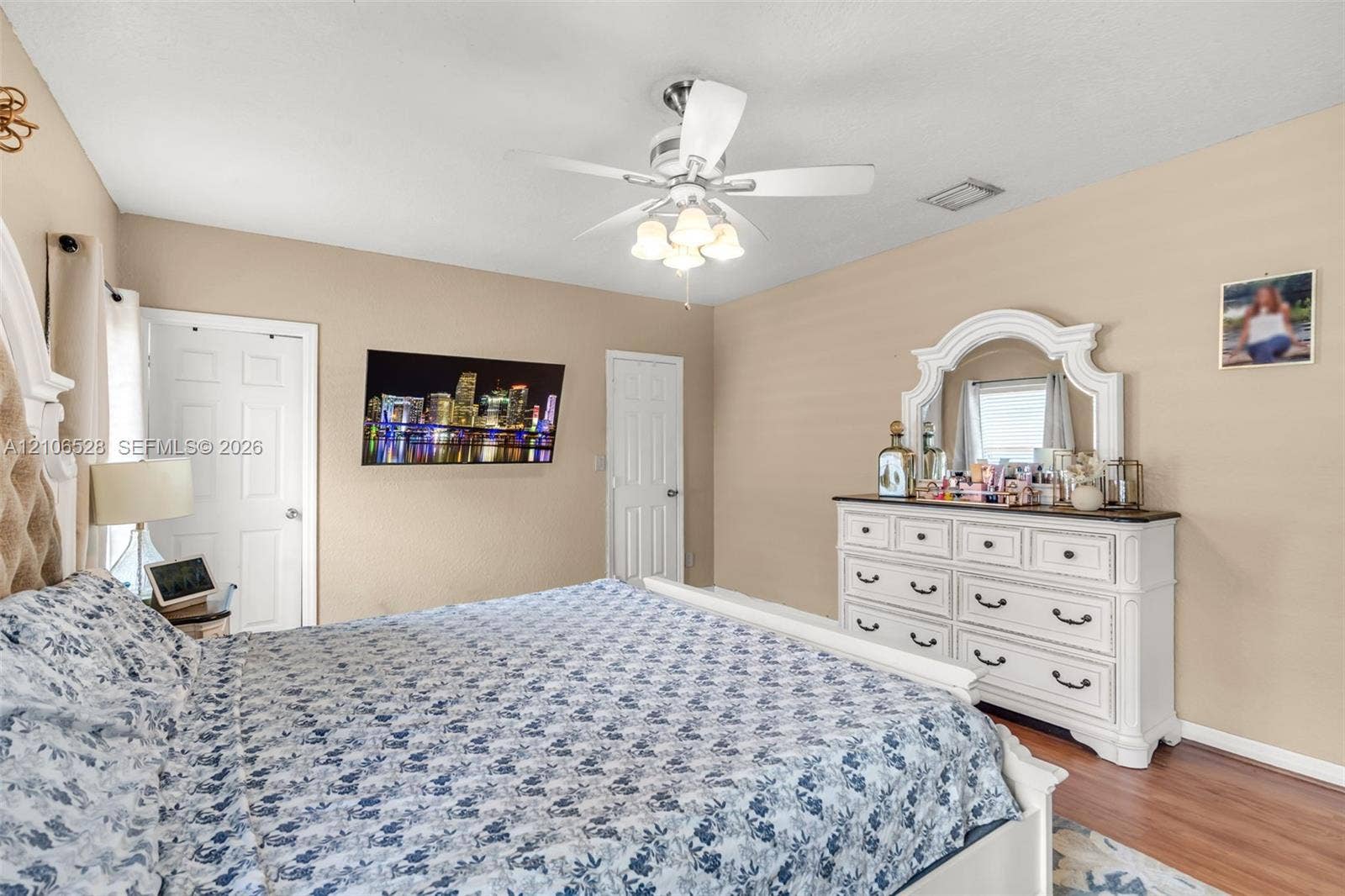 2615 NW 14th Street, Fort Lauderdale, FL 33311 Bedroom featuring wood-finish flooring, multi-paneled interior doors, and a ceiling-mounted light fixture with a fan