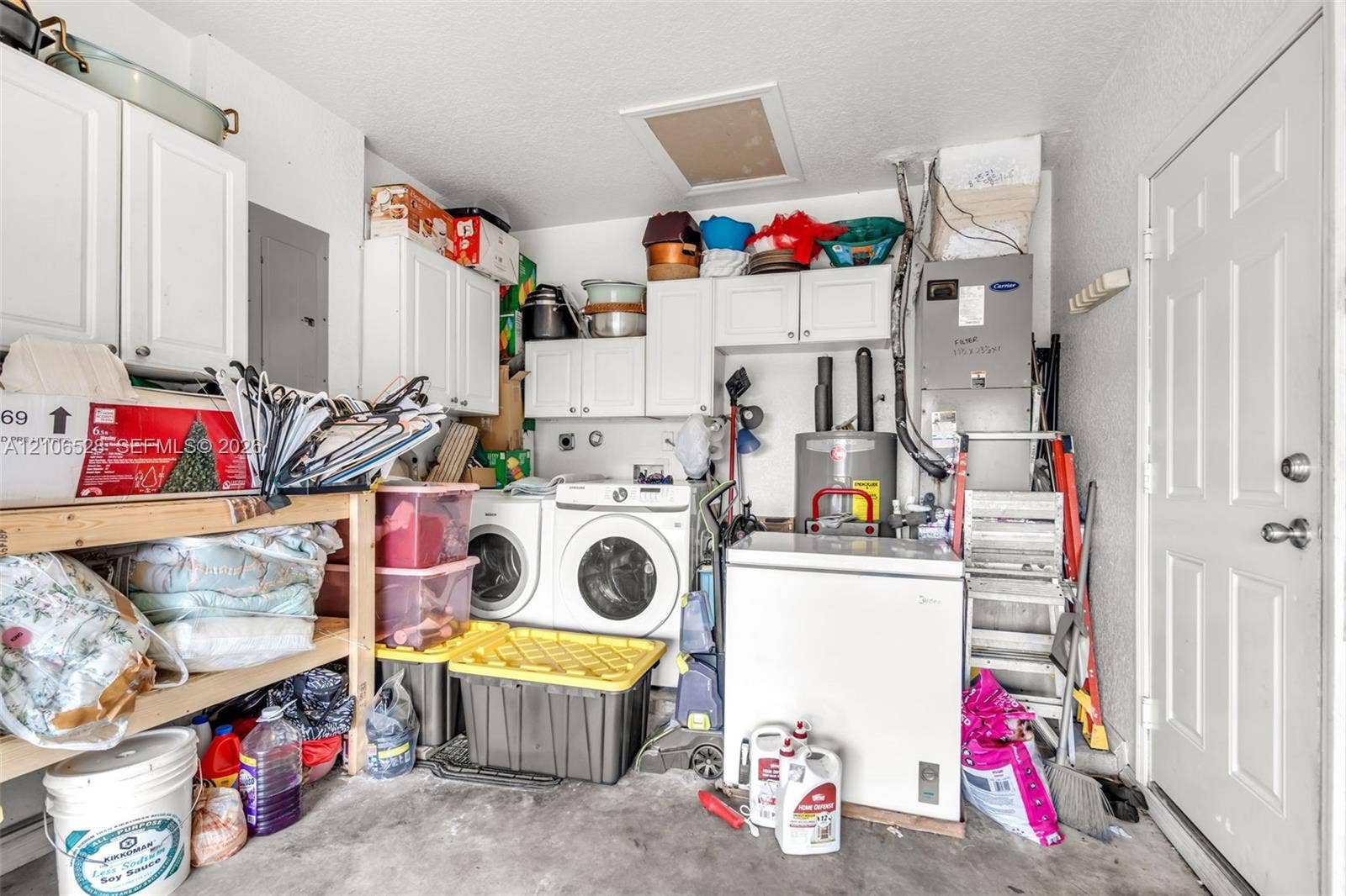 2615 NW 14th Street, Fort Lauderdale, FL 33311 Utility space featuring white cabinetry, a dedicated laundry area, a water heater, and an HVAC system
