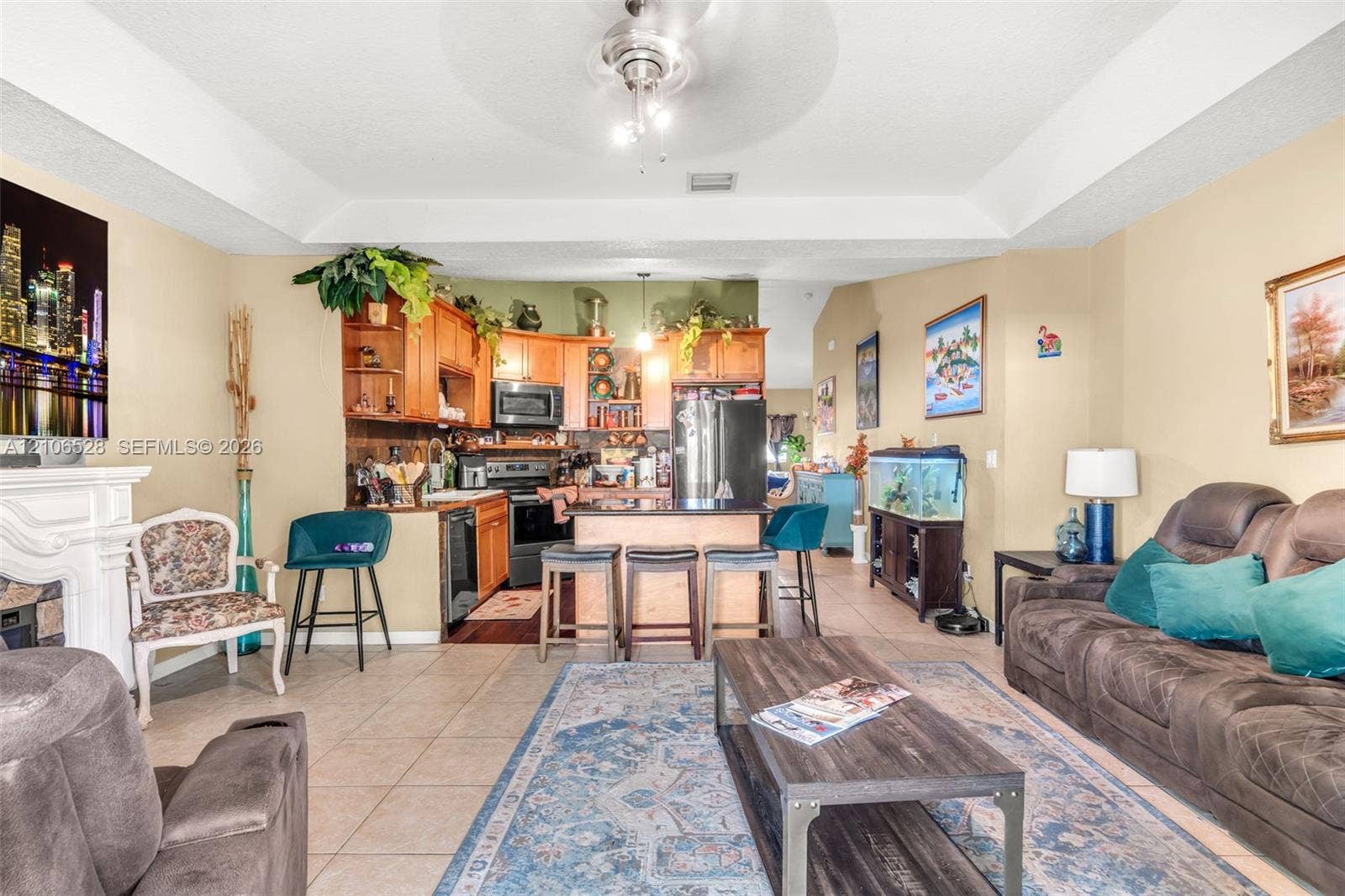 2615 NW 14th Street, Fort Lauderdale, FL 33311 Tray ceiling, wood cabinetry, built-in fireplace, and kitchen island with seating