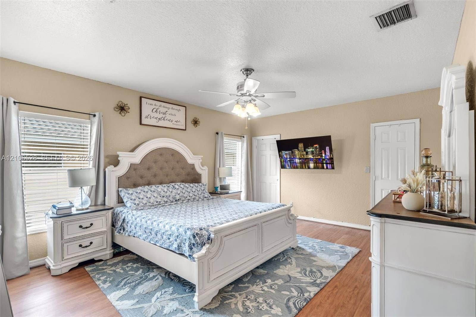 2615 NW 14th Street, Fort Lauderdale, FL 33311 Spacious interior featuring wood-finish flooring, a ceiling fan with integrated lighting, dual windows with blinds, and paneled doors