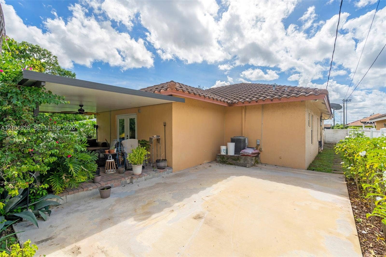 2615 NW 14th Street, Fort Lauderdale, FL 33311 Covered concrete patio with a brick border, concrete hardscaping, tile roofing, and stucco exterior