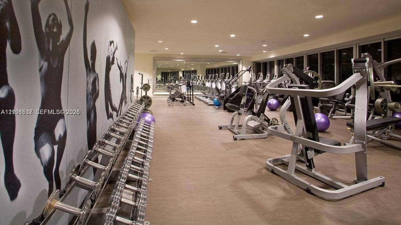 465 Brickell Avenue, #5203, Miami, FL 33131 Fitness center featuring wall-to-wall mirrors, recessed lighting, and extensive floor-to-ceiling glass windows
