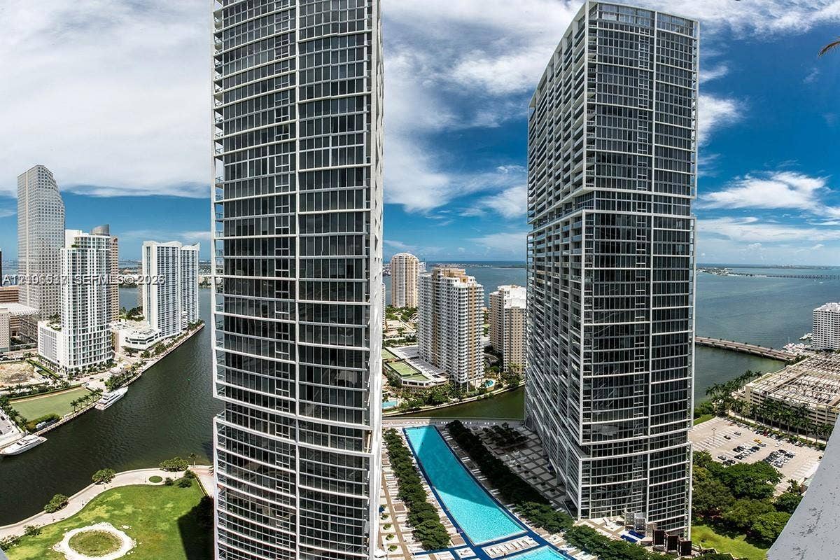 465 Brickell Avenue, #5203, Miami, FL 33131 High-rise residential towers featuring floor-to-ceiling glass facades, a linear outdoor swimming pool, and a waterfront location