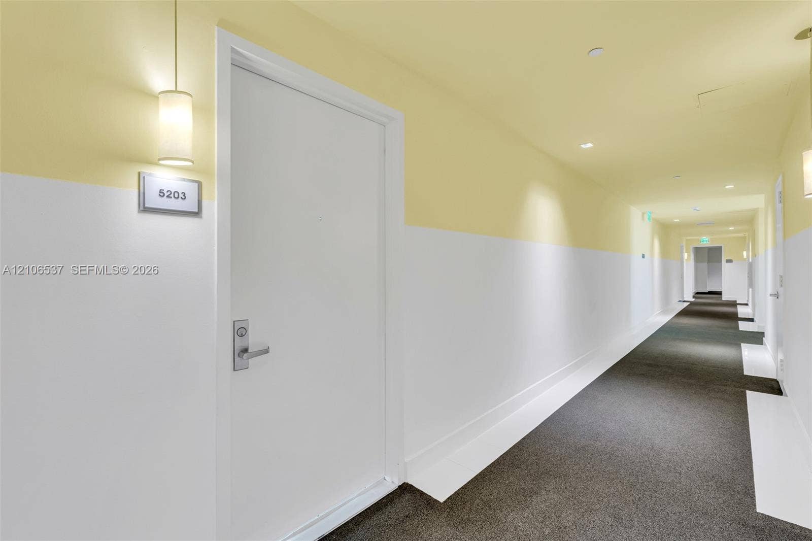 465 Brickell Avenue, #5203, Miami, FL 33131 Hallway featuring two-tone wall paint, recessed lighting, carpeted flooring, and wall-mounted cylindrical sconces