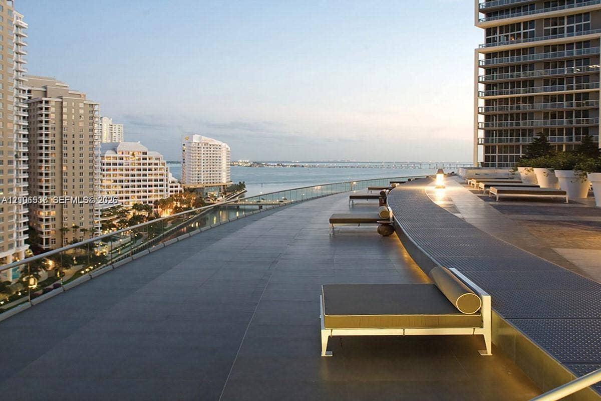465 Brickell Avenue, #5203, Miami, FL 33131 Expansive outdoor terrace featuring large-format tile flooring, a glass panel railing, and integrated linear ground lighting