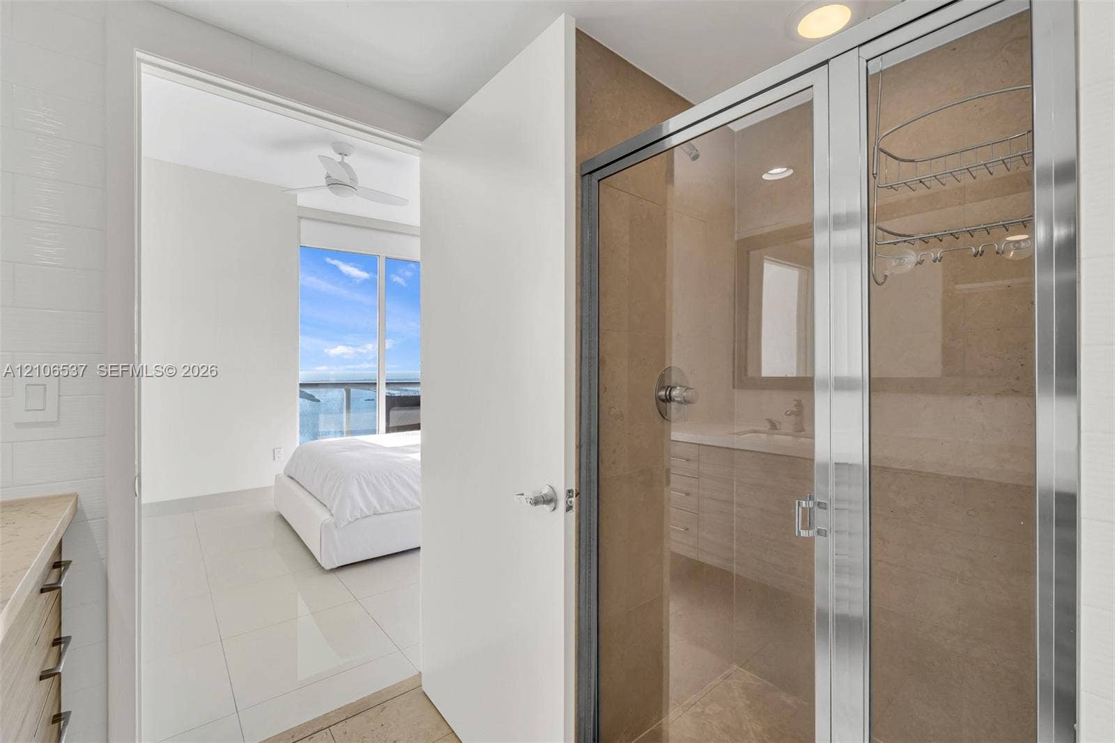 465 Brickell Avenue, #5203, Miami, FL 33131 Glass-enclosed shower with tiled surround, stone-top vanity, tile flooring, and recessed lighting