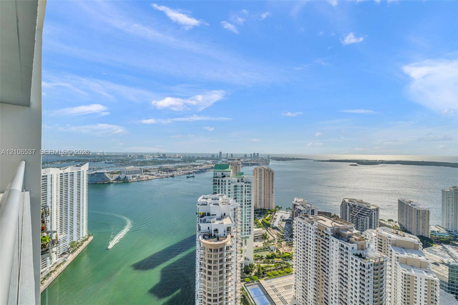 465 Brickell Avenue, #5203, Miami, FL 33131 High-rise balcony featuring a metal railing, spanning an expansive, elevated perspective of the surrounding bay, skyline, and coastal waters