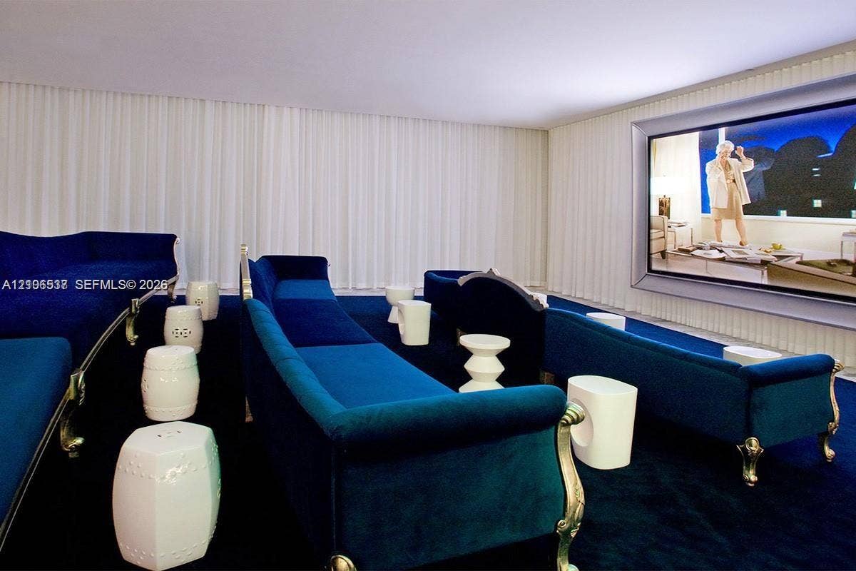 465 Brickell Avenue, #5203, Miami, FL 33131 Media room featuring a recessed wall-mounted screen, floor-to-ceiling drapery, and wall-to-wall carpeting