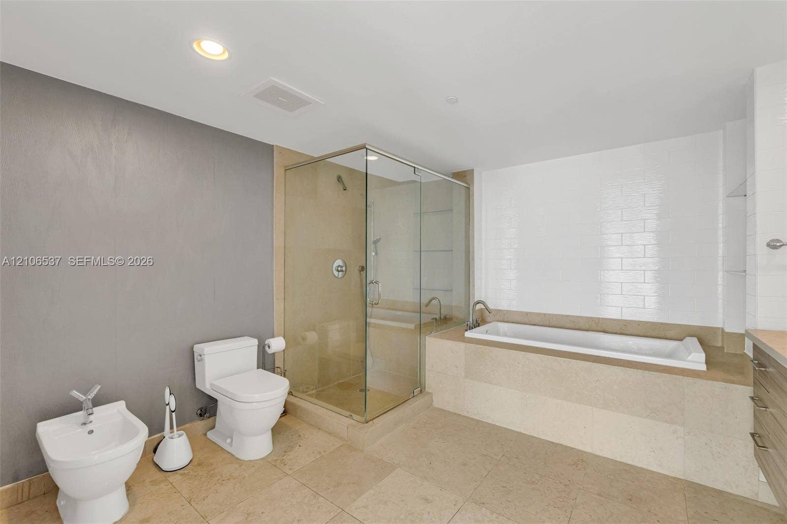 465 Brickell Avenue, #5203, Miami, FL 33131 Bathroom featuring a glass-enclosed shower, a deep soaking tub with tile surround, porcelain tile flooring, and a bidet