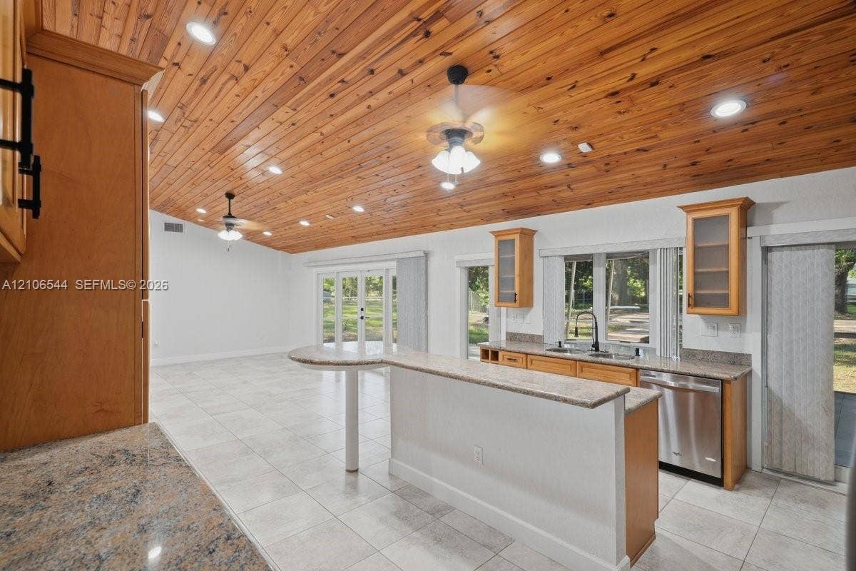 Wood-plank ceiling featuring exposed beams, tile flooring, built-in cabinetry, and recessed lighting