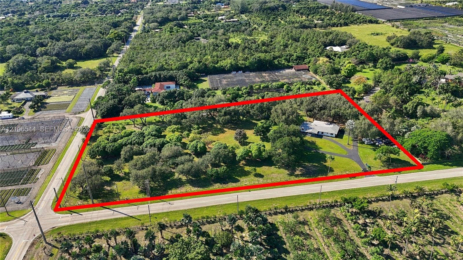 Expansive parcel featuring mature oak trees, paved driveway, and established landscape