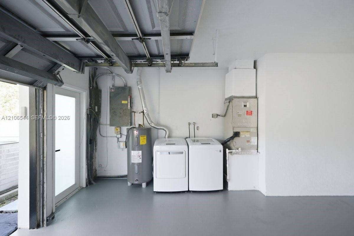Garage space featuring a painted concrete floor, side-entry door, water heater, and mechanical systems