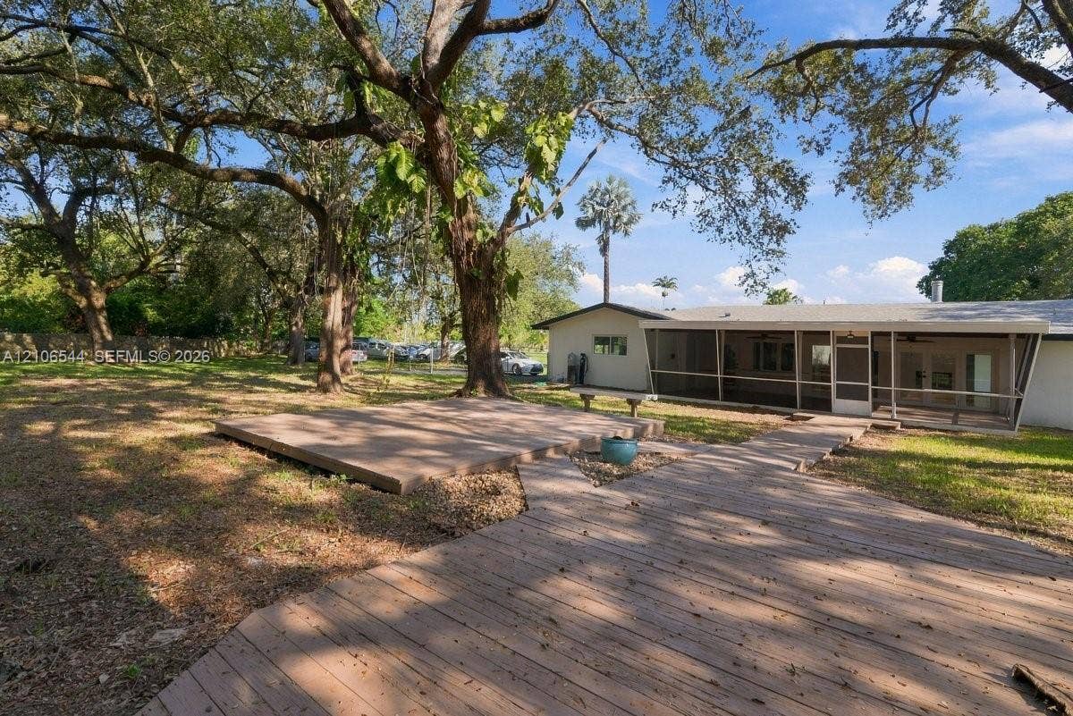 Expansive lot featuring mature hardwood trees and a detached structure with an attached gazebo