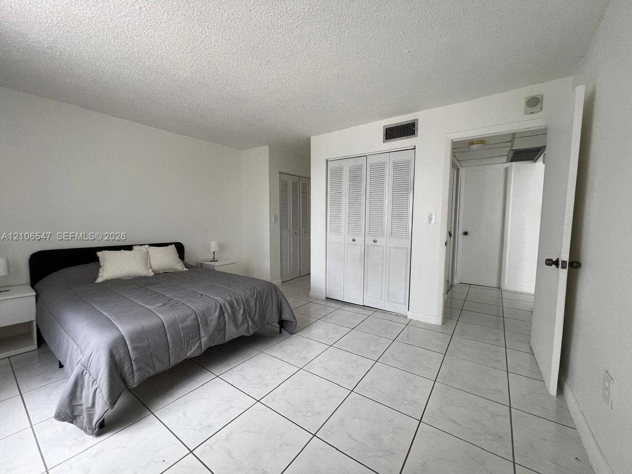 6801 Indian Creek Drive, #509, Miami Beach, FL 33141 Room featuring white tile flooring, dual louvered-door closets, and a neutral color palette