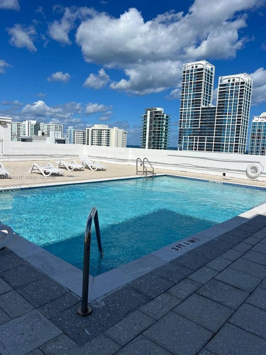 6801 Indian Creek Drive, #509, Miami Beach, FL 33141 Rooftop swimming pool with stainless steel handrails, expansive stone-paver decking, and perimeter wall safety railing