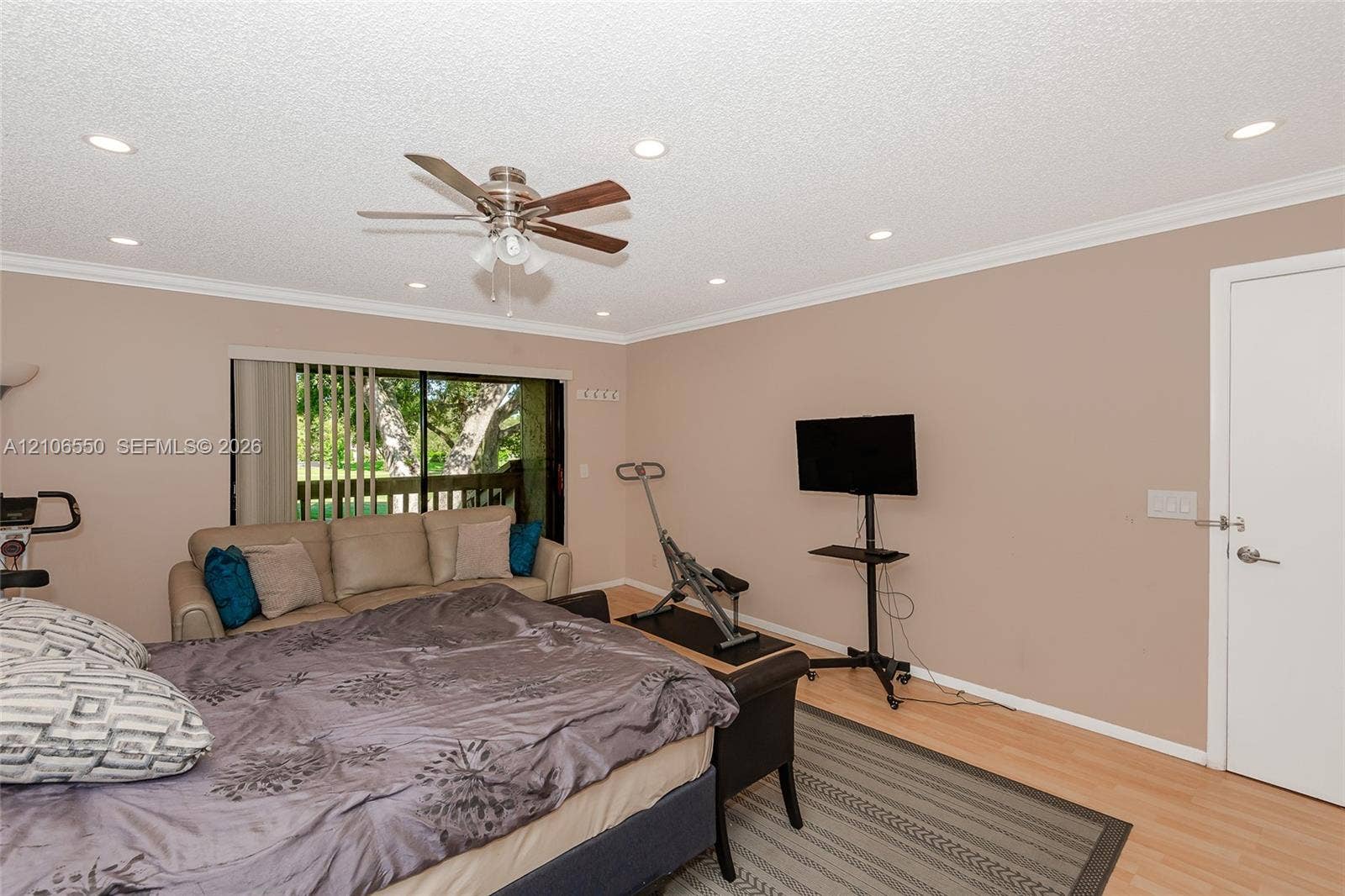 Room featuring wood-finish flooring, recessed lighting, a ceiling fan with integrated light kit, and a sliding glass door
