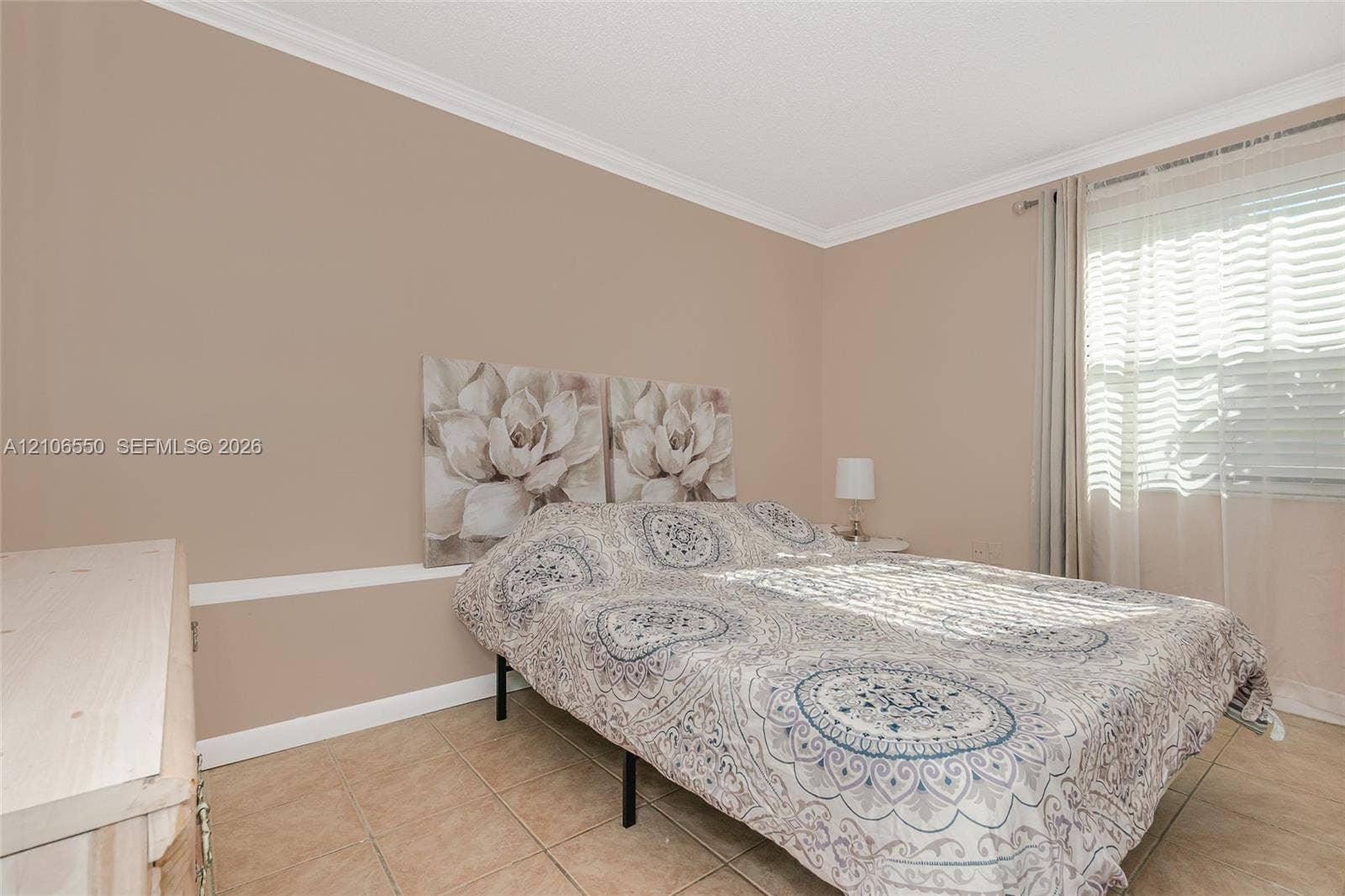 Neutral wall tones, crown molding, chair rail detailing, ceramic tile flooring, and a large window with horizontal blinds