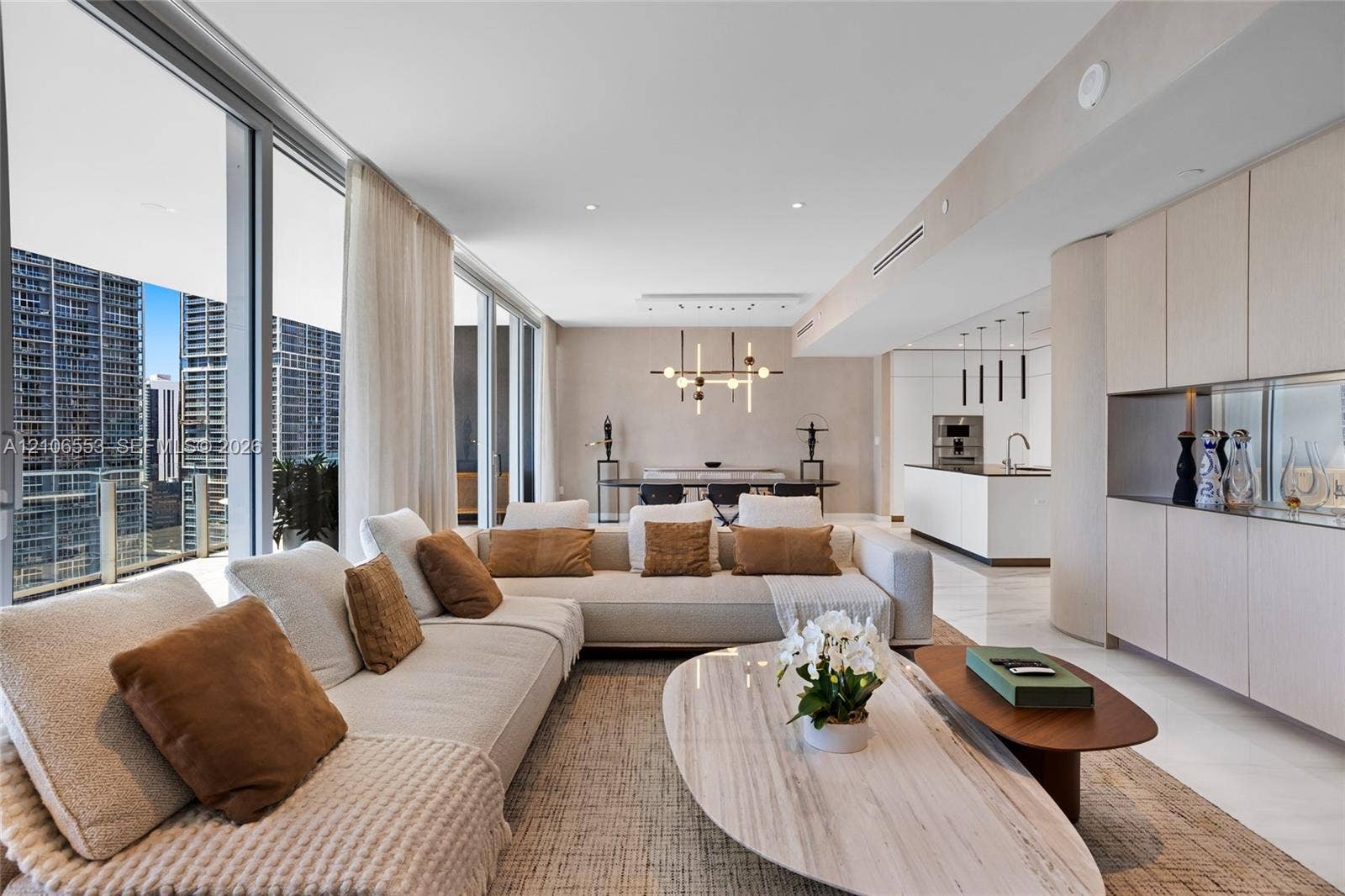 300 Biscayne Boulevard Way, #3002E, Miami, FL 33131 Floor-to-ceiling glass windows, expansive stone flooring, integrated cabinetry, modern linear light fixtures, and white waterfall-edge kitchen island