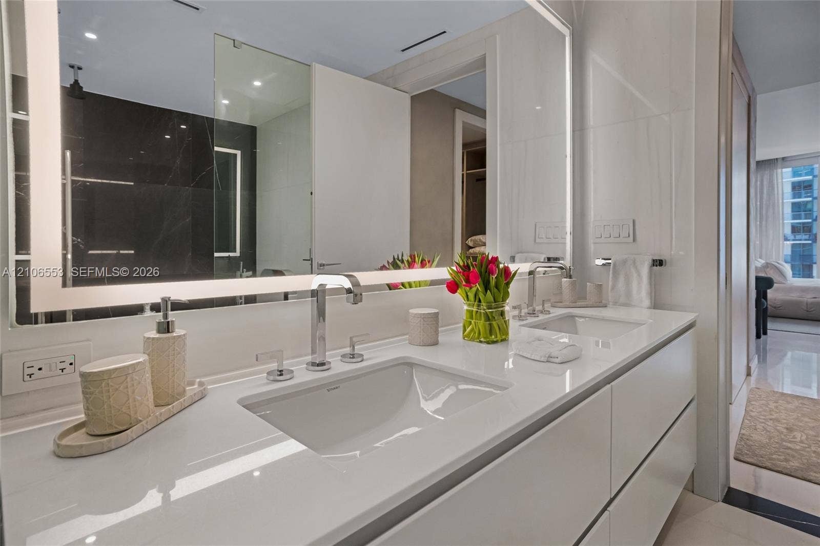 300 Biscayne Boulevard Way, #3002E, Miami, FL 33131 Floating double vanity featuring a seamless countertop with integrated dual sinks, chrome widespread faucets, and a large wall-mounted mirror with integrated perimeter lighting