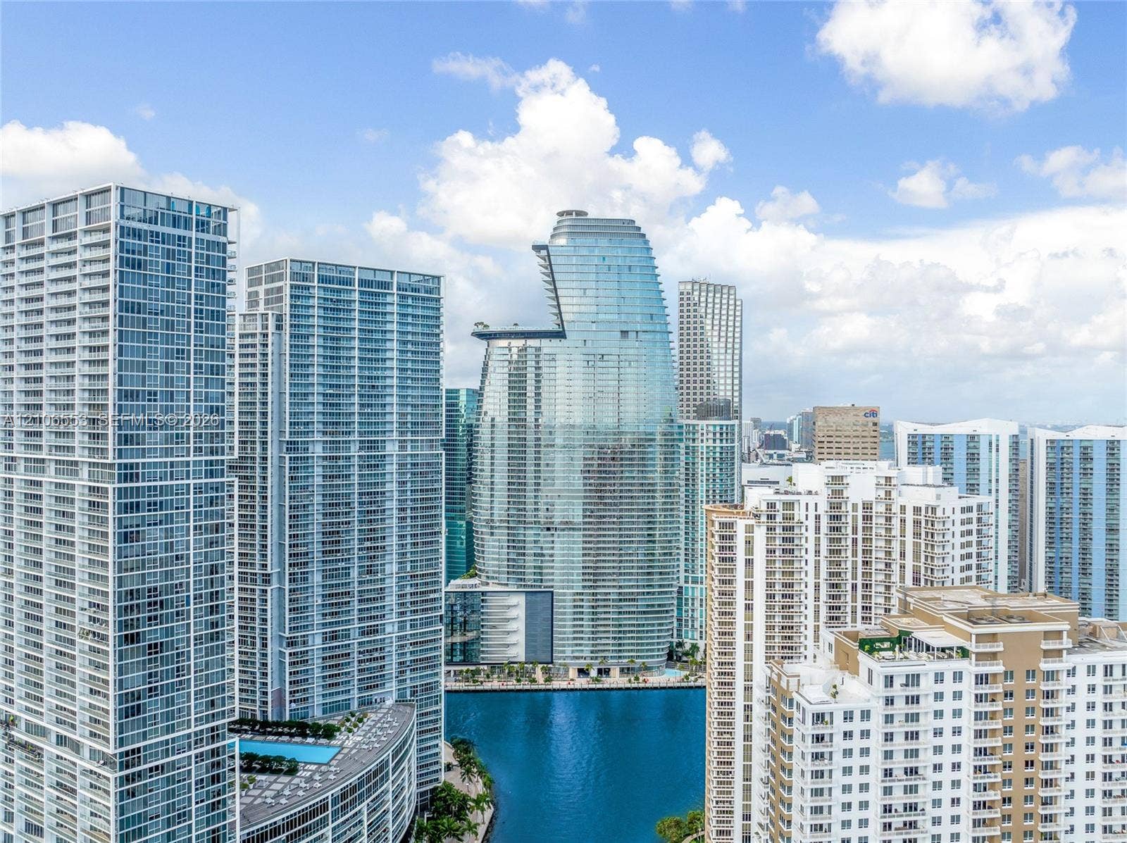 300 Biscayne Boulevard Way, #3002E, Miami, FL 33131 High-rise urban landscape featuring glass-clad skyscrapers, balcony-lined exterior facades, and water frontage