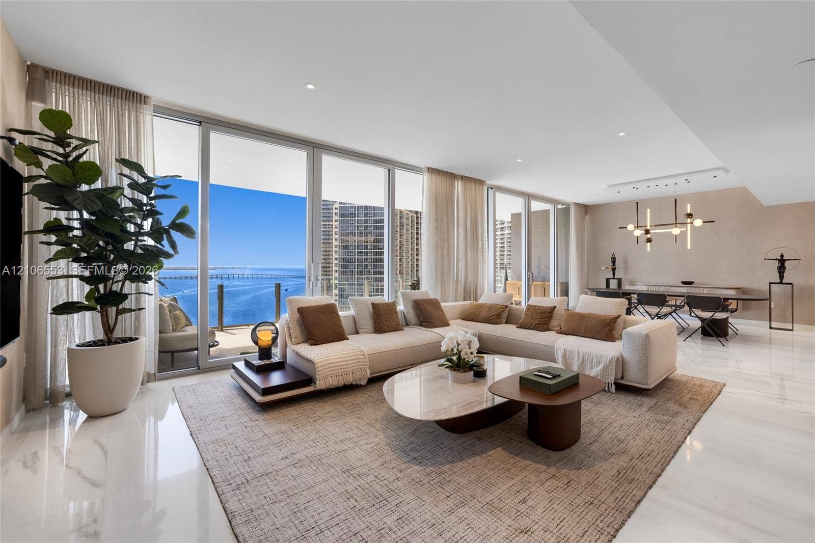 300 Biscayne Boulevard Way, #3002E, Miami, FL 33131 Open-concept living space featuring floor-to-ceiling glass sliding doors, polished stone-finish flooring, recessed lighting, and a modern tiered chandelier