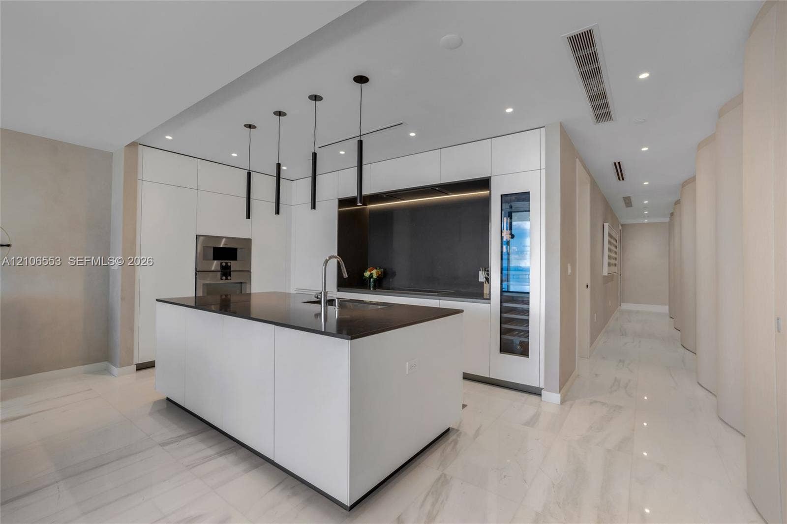 300 Biscayne Boulevard Way, #3002E, Miami, FL 33131 Modern kitchen featuring a central island with a stone-surface countertop, flat-panel cabinetry, integrated wine refrigeration, and matte black linear pendant lighting