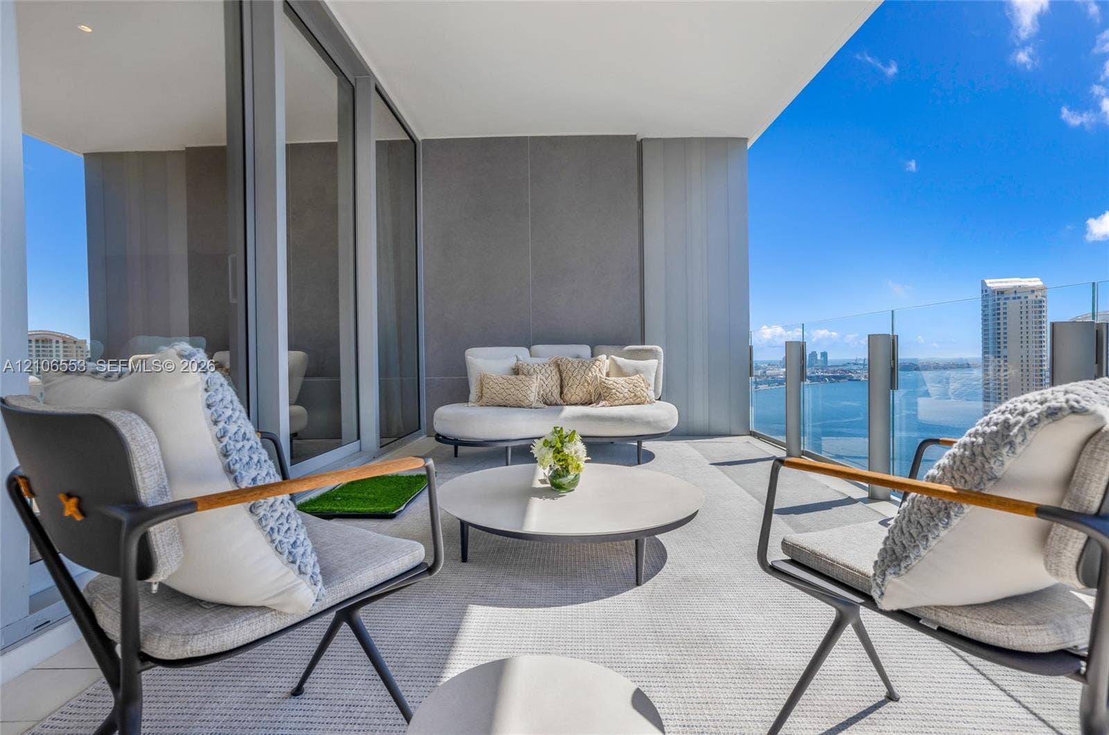 300 Biscayne Boulevard Way, #3002E, Miami, FL 33131 Covered balcony featuring expansive glass-panel railings, large-format tile flooring, and floor-to-ceiling sliding glass doors
