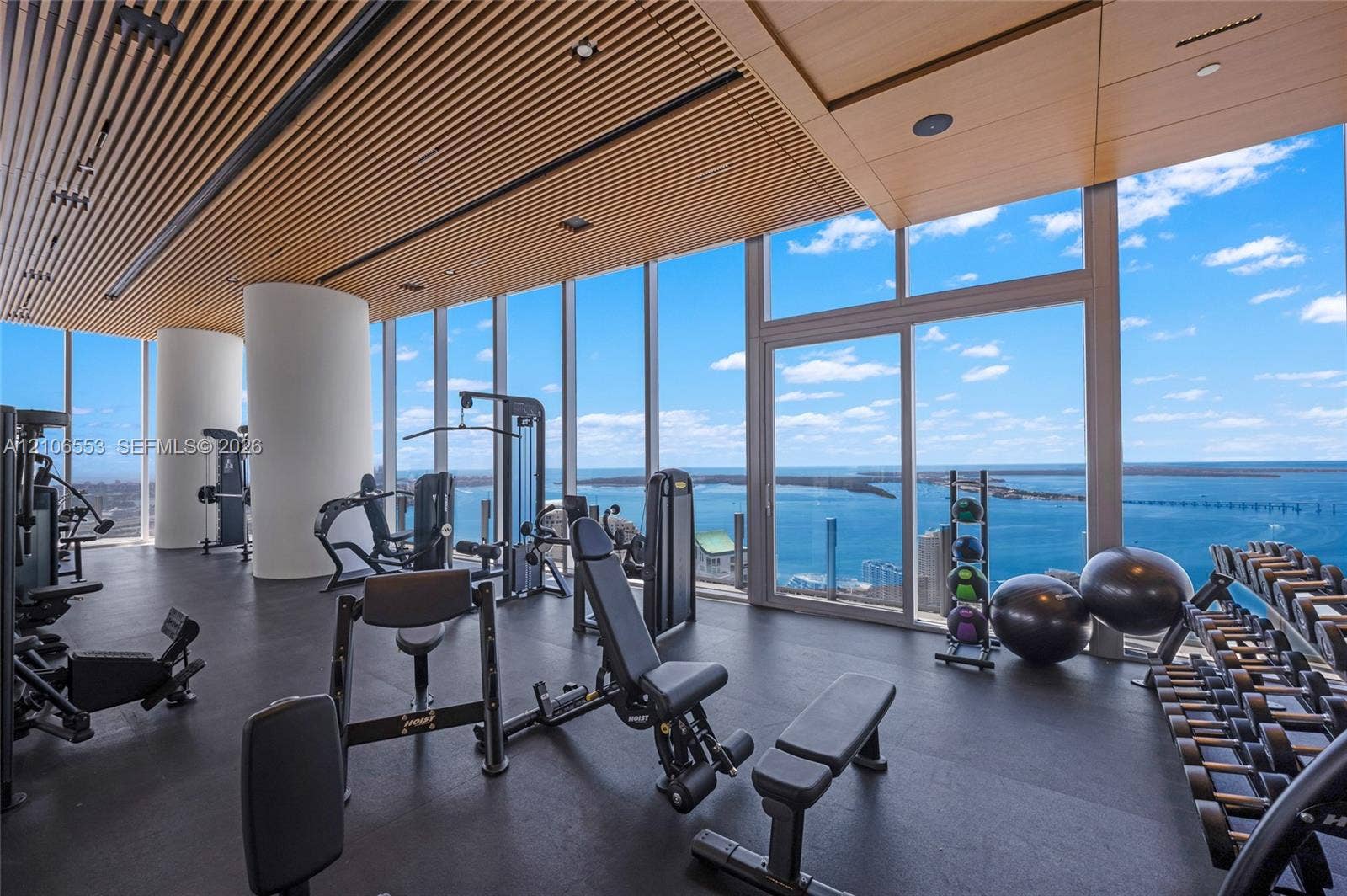300 Biscayne Boulevard Way, #3002E, Miami, FL 33131 Fitness space featuring floor-to-ceiling windows, slatted wood-finish ceiling, rubberized flooring, and structural columns