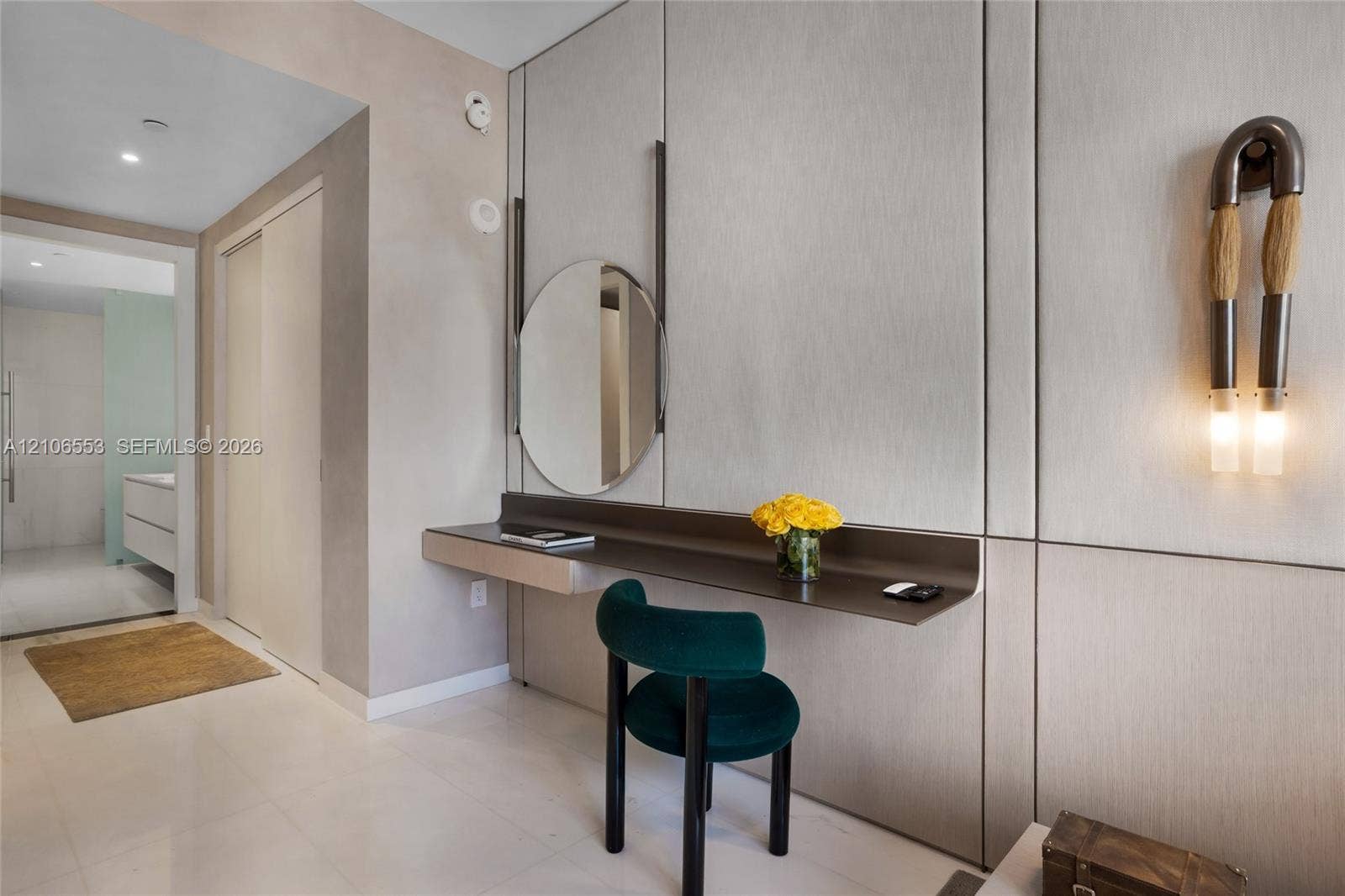 300 Biscayne Boulevard Way, #3002E, Miami, FL 33131 Built-in floating desk with integrated shelving, wall-mounted circular mirror, full-height paneled wall cladding, and contemporary vertical wall sconces