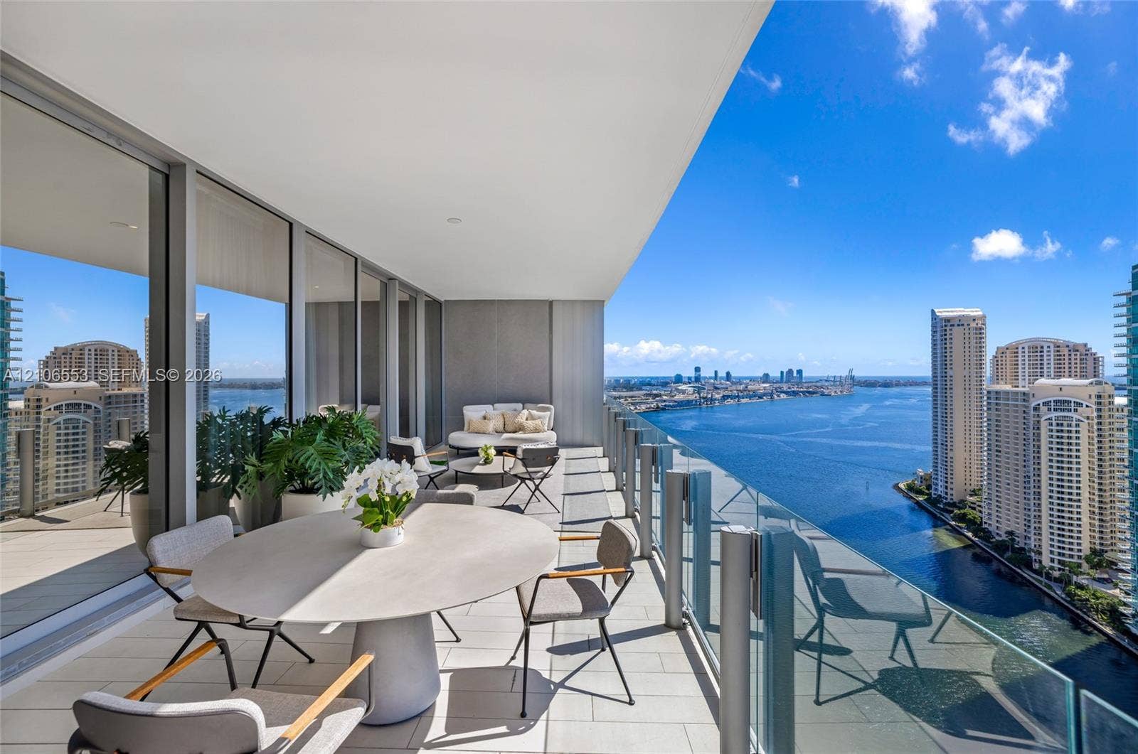 300 Biscayne Boulevard Way, #3002E, Miami, FL 33131 Expansive covered balcony featuring large-format tile flooring, recessed ceiling lighting, and a floor-to-ceiling glass railing